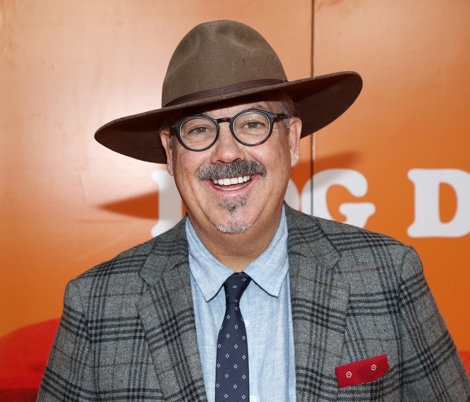 Duncan Sheik con gafas y sombrero ante un fondo naranja